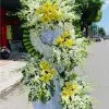 Vòng hoa viếng đám tang từ biệt gồm hoa lan trắng và hoa ly vàng.